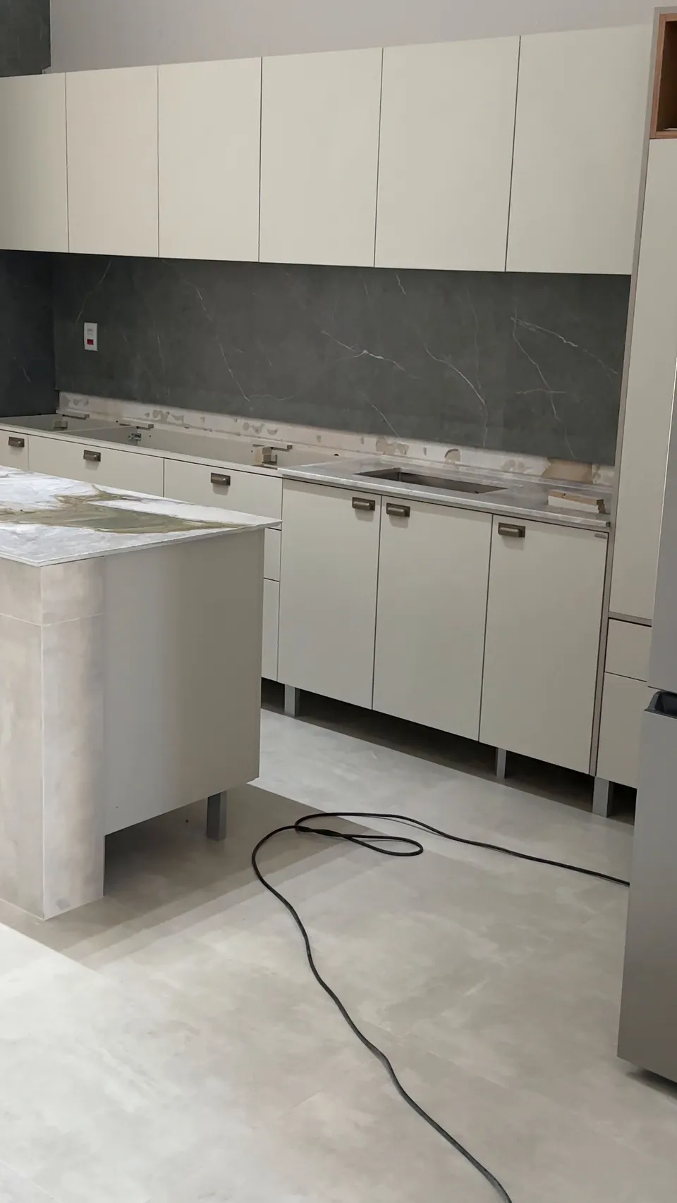 Cozinha em obra, com a bancada sendo instalada.