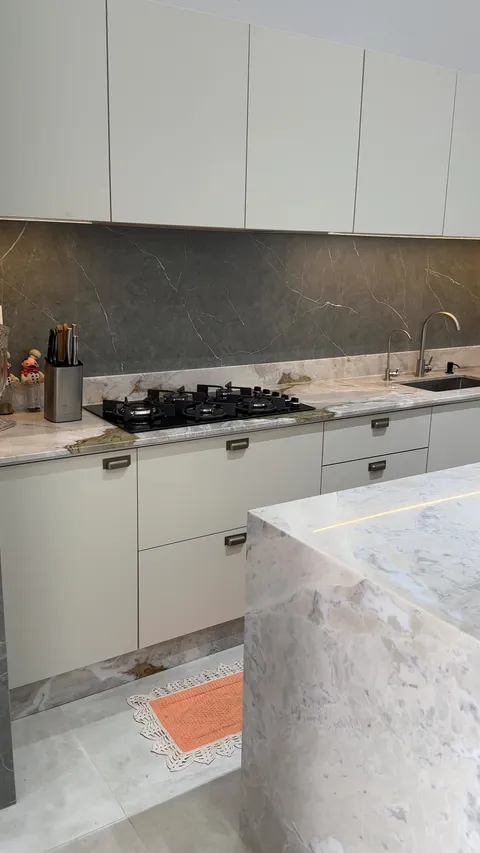 Ilha de cozinha em quartzito com veio verde e dourado.